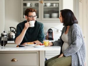 couple discussing mortgage payments at the breakfast table: who pays for private mortgage insurance on a mortgage