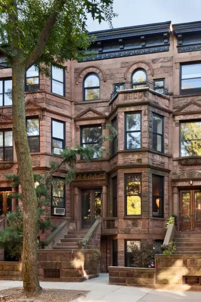 A brownstone stoop and the sidewalk in front of it, which is where the liability question lives