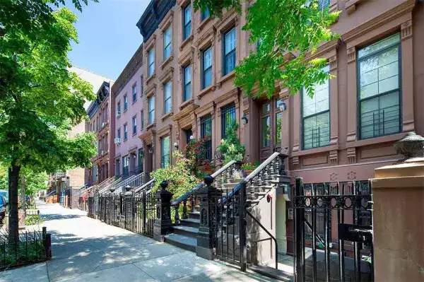 A row of New York townhouses, where the difference that matters is not visible from the street