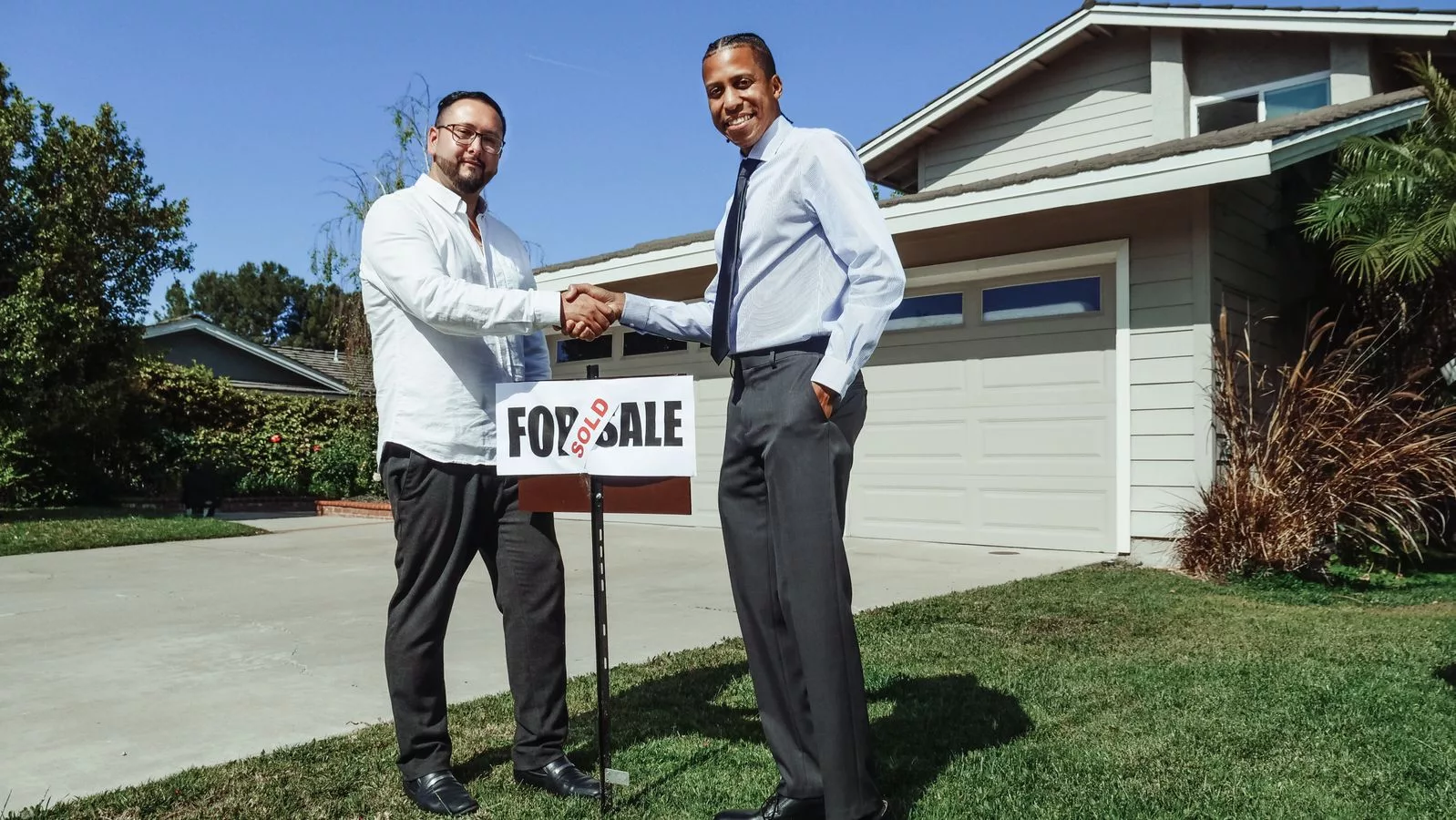 A real estate agent and client reviewing license credentials before signing