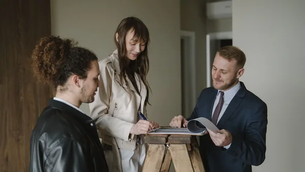 A buyer and a real estate professional going over deal paperwork