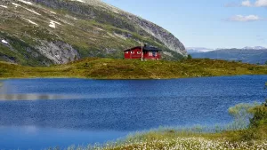A small red cabin on a lake, a classic second-home setting