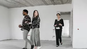 A licensed New York agent showing an empty apartment to a couple