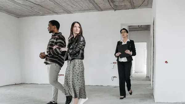 A licensed New York agent showing an empty apartment to a couple