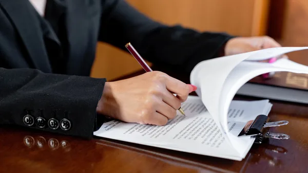 A real estate attorney reviewing a purchase contract at a desk