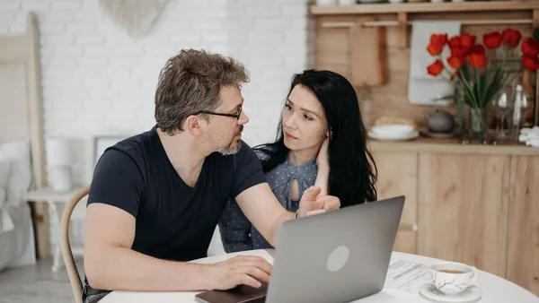 A couple weighing renting against buying at their kitchen table