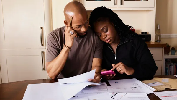 A first-time buyer couple going over paperwork and costs at home