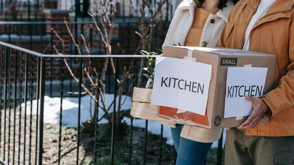 Someone carrying labelled moving boxes down a NYC stoop