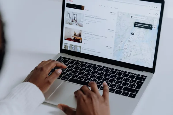 A NYC buyer working out affordability numbers on a laptop with listings open