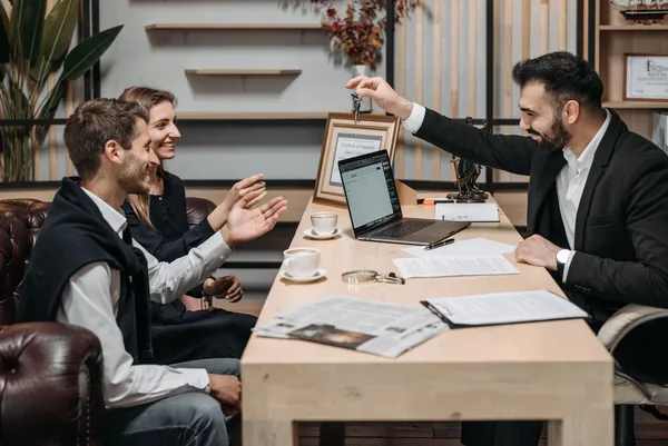 A licensed New York broker handing keys to buyers after a closing