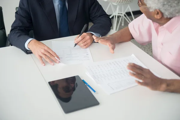 A buyer and their attorney reviewing an assumable loan's terms with a lender