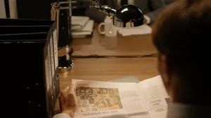 A person reviewing property documents alone under a desk lamp