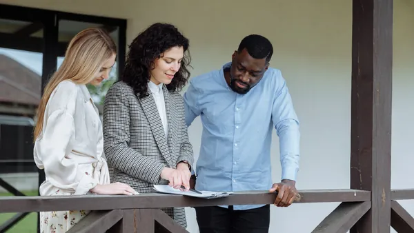 Three people reviewing a home purchase on a laptop - can you buy a house without a realtor