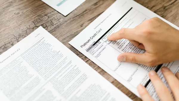 A hand signing a multi-page agreement with a pen