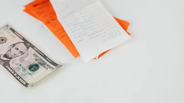Cash and receipts beside a signed agreement on a desk
