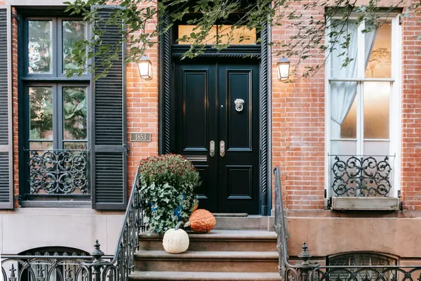 The stoop and iron railing of a landmarked NYC brownstone - buying a historic home