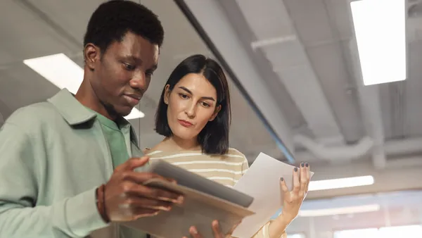 Two colleagues reviewing a document on a tablet together