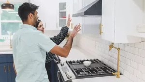 Buyers testing the range hood and stove during a final walkthrough