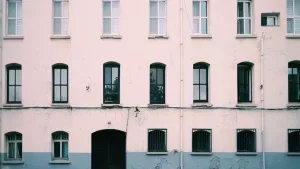 The exterior of an older apartment building with visibly worn paint