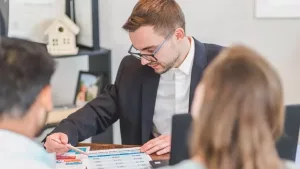 An agent walking clients through paperwork at the office