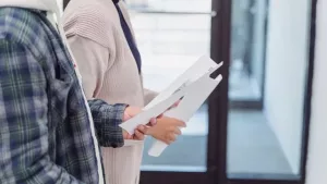 nys disclosure form for landlord and tenant - Two tenants holding lease paperwork while touring an apartment