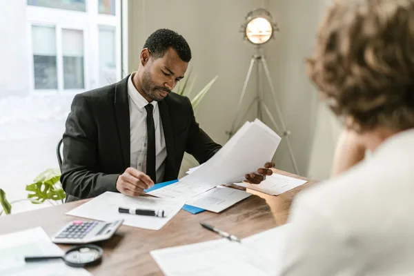 Two signed purchase contracts side by side on a NYC broker's desk