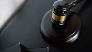 A wooden gavel resting on a dark desk