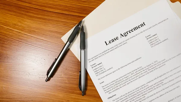 A lease agreement document with a pen resting on it - broker fee law nyc