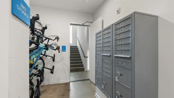 A co-op building lobby with a mailbox wall of monthly statements
