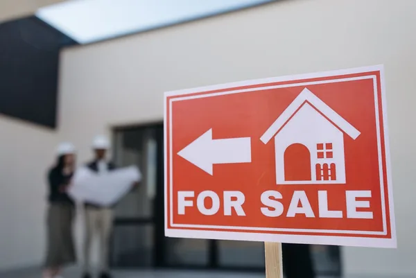 A for-sale sign outside a building a renter is deciding whether to buy into