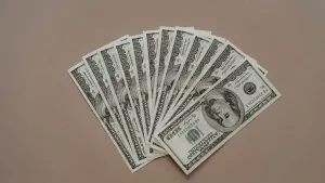US one hundred dollar bills fanned out on a plain surface