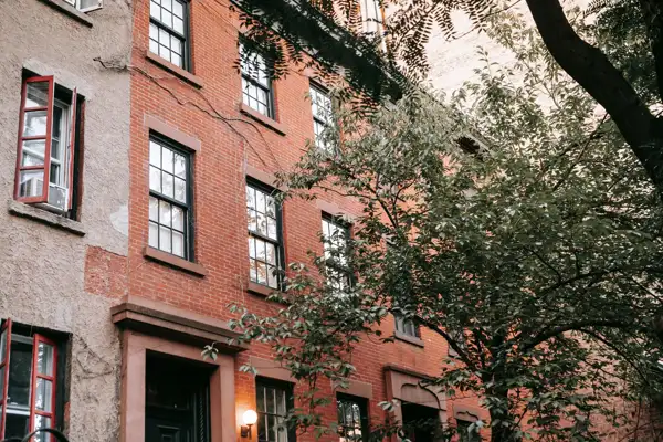 Brick townhouses on a tree-lined New York City block